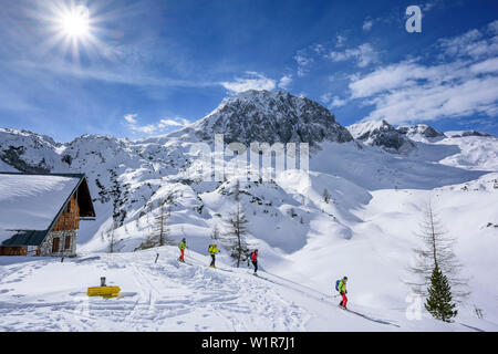 Quattro persone sci backcountry discendente dalla capanna Laufener Huette, Fritzerkogel in background, capanna Laufener Huette, Tennengebirge range, Salisburgo, Foto Stock