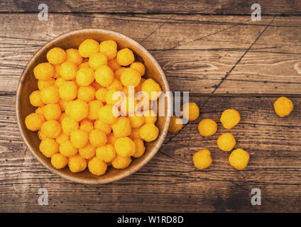 Golden soffiato palline di formaggio come classico snack per bambini su legno. Vista superiore Foto Stock