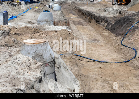 Calcestruzzo drenante, fosse settiche e pozzi in un cantiere. Foto Stock