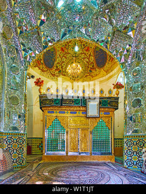 KASHAN, IRAN - 23 ottobre 2017: la sala da preghiera di Imamzadeh Ibrahim Mausoleo con sarcofago, circondato da ornato mirrorwork, dipinte e con piastrelle p Foto Stock