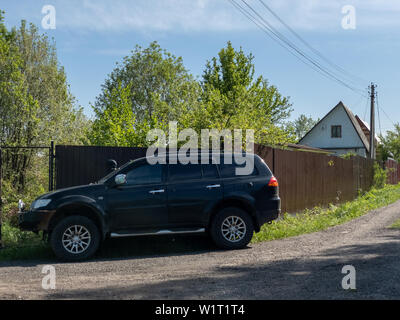 Mosca, Russia - 24 Maggio 2019: Nero Mitsubishi Pajero Sport auto parcheggiate vicino alla recinzione di una casa di campagna Foto Stock
