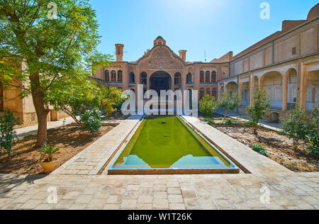 KASHAN, IRAN - 23 ottobre 2017: Birouni (esterno) della Borujerdi casa storica con splendidi motivi scolpiti di pareti e fontana rettangolare in mezzo Foto Stock