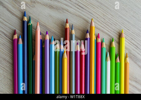 Il gruppo di una lunghezza differente disegno colorato le matite sono posa sulla scrivania in legno di sfondo e in attesa di una Lezione di pittura. Foto Stock