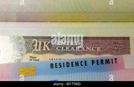 Regno Unito BRP biometrici (Permesso di soggiorno) schede per Tier 2 visto di lavoro posizionata sulla parte superiore del Regno Unito Entry Clearance vignette sticker nel passaporto. Foto Stock