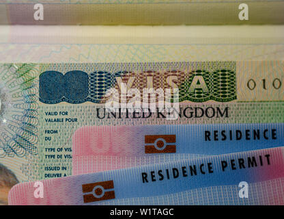 Regno Unito carte di BRP per Tier 2 visto di lavoro posizionata sulla parte superiore del Regno Unito Business vignetta visto nel passaporto. Close up foto. Foto Stock