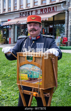 Riproduzione di uomo con organetto nella stazione ferroviaria Tatranska Lomnica. Giorno della festa dei lavoratori. Slovacchia Foto Stock