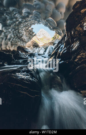 Fiume di montagna attraverso la neve vecchia caverna , E5, Alpenüberquerung, 1° stadio Oberstdorf Sperrbachtobel a Kemptnerhütte, Algovia, Baviera, Alpi, Germania Foto Stock