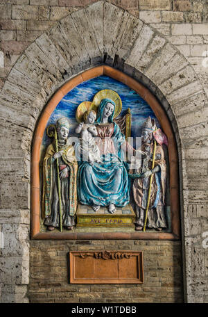 La Madonna e il bambino scultura sotto i portici di Via Maesta delle volte a Perugia, Umbria, Italia Foto Stock