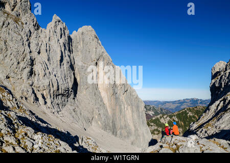 L uomo e la donna seduta al Ellmauer Tor e guardando verso Christaturm e Fleischbank, Ellmauer Tor, Wilder Kaiser, Kaiser gamma, Tirolo, Austria Foto Stock