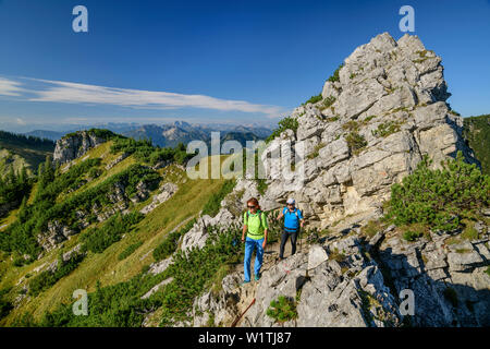 Un uomo e una donna che cammina su, passando a Aiplspitze Aiplspitze Mangfall, montagne, Alpi Bavaresi, Alta Baviera, Baviera, Germania Foto Stock