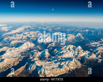 Fotografia aerea durante il tramonto con la luna al di sopra delle Dolomiti, Veneto, Italia Foto Stock