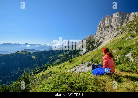 La donna durante le escursioni si siede sul paragrafo e si affaccia su uno scenario di montagna, il Grand Veymont, Vercors, Dauphine, Dauphine, Isère, Francia Foto Stock