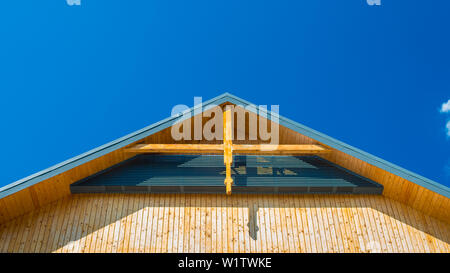Il frammento dell'Highlander la facciata di una casa tradizionale fotografato dal di sotto - contro il cielo blu Foto Stock