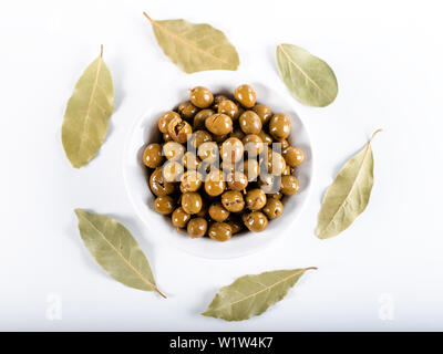Olive verdi in vaso con foglie di Daphne su sfondo bianco, olive da Antakya, Turchia. Foto Stock