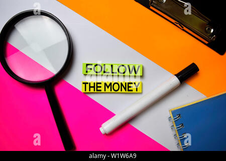 Seguire il testo di denaro su foglietti adesivi con colore office desk concept Foto Stock