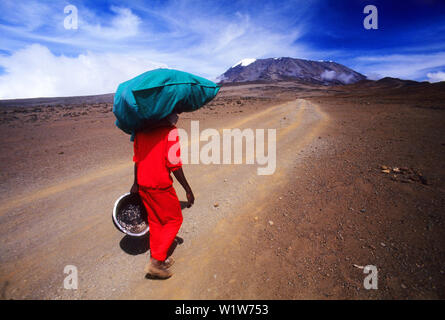 Porter attraversando il Sadlle sul modo di Mt. Kilimanjaro, il punto più alto in Africa con 5895 metri sopra il livello del mare, Tanzania Foto Stock