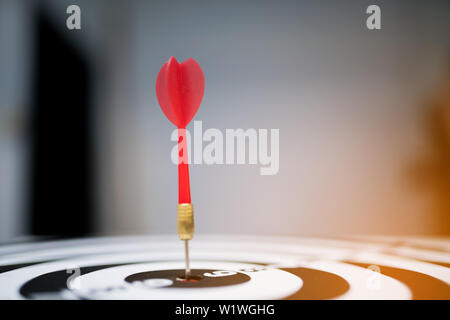 Rosso freccia dart di colpire nel target center di dartboard Foto Stock