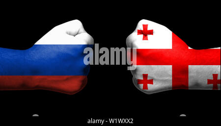 Bandiere di Russia e Georgia dipinta su due pugni rinserrata affacciati su sfondo nero/rapporto teso tra la Russia e la Georgia concept Foto Stock