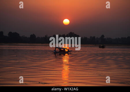 Srinagar. 3 Luglio, 2019. Foto scattata il 3 luglio 2019 mostra un barcaiolo canottaggio la sua barca durante il tramonto a dal lago in Srinagar city, la capitale estiva di Indiano-Kashmir controllata. Credito: Javed Dar/Xinhua/Alamy Live News Foto Stock