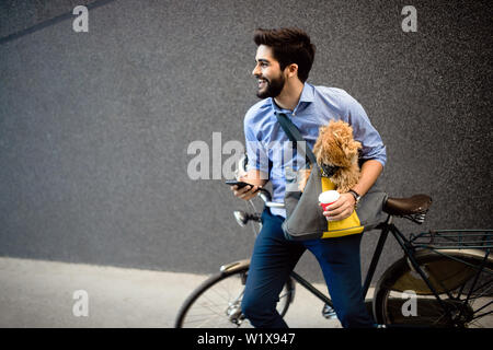 Stile di vita, di trasporto, di comunicazione e di concetto di persone . Giovane uomo con la bicicletta e smartphone su una strada di città Foto Stock