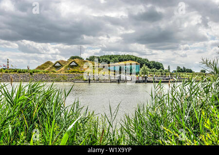 Werkendam, nei Paesi Bassi il 3 luglio, 2019: vista tra canne in tutta l'acqua verso il suolo coperto di Biesbosch il museo, il ristorante e il molo Foto Stock