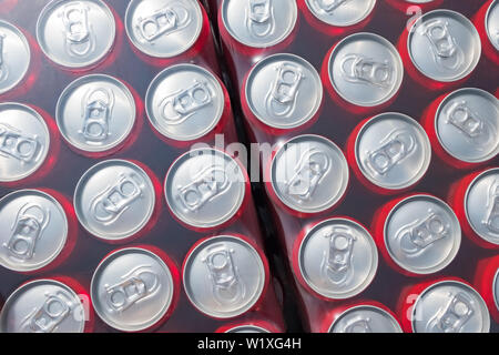 Rosso di lattine in alluminio imballati in background plastick Foto Stock