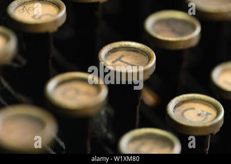 Una macro immagine di una macchina da scrivere vintage chiave rotonda tastiera. DOF è molto profondo e il tasto T è messa a fuoco al vicino al centro dell'inquadratura. Foto Stock