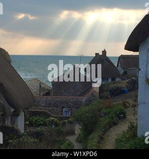 La luce del sole si rompe in su Cadgwith Cove, Cornwall Foto Stock