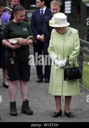 La regina Elisabetta II con il detentore Maia Gordon come Olive l anatra cammina accanto a loro durante una visita alla città di Gorgie agriturismo a Edimburgo. Foto Stock