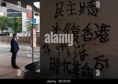 Hong Kong, Cina. 04 Luglio, 2019. Un " commuter " attende che il bus vicino all'edificio del Consiglio legislativo e di prossimità che è stato vandalizzato da anti extradition bill contestatori. Credito: SOPA Immagini limitata/Alamy Live News Foto Stock