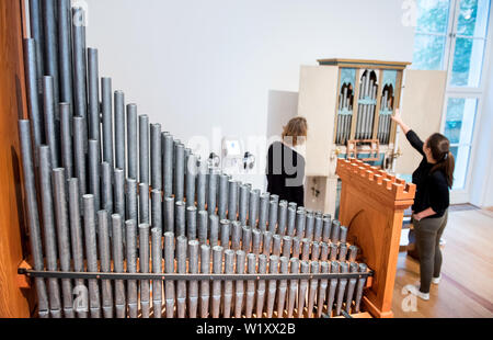 Amburgo, Germania. 04 Luglio, 2019. Due donne sono alla ricerca di ogni altro nel Museum für Kunst und Gewerbe nella mostra Manufaktur des Klangs. 2000 anni di costruzione di organi e di organo a suonare in un organo durante un incontro con la stampa. Più di 30 mostre, tra cui 14 strumenti storici e ricostruzioni, vi invitano a conoscere la progettazione strutturale e la raffinatezza tecnica dell'organo Wunderwerk nella mostra. Credito: Daniel Bockwoldt/dpa/Alamy Live News Foto Stock