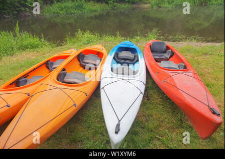 Quattro kayak sulla riva del fiume, sports kayak sulle rive del laghetto Foto Stock