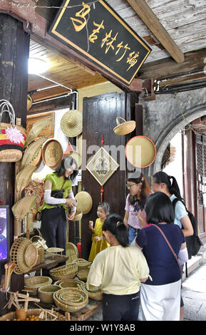 (190704) -- DEQING, 4 luglio 2019 (Xinhua) - Visitatori acquistare striscia di bambù maglia prodotti in Xinshi township di Deqing County, est della Cina di Provincia dello Zhejiang, 4 luglio 2019. Ma Jilin, 74 è un ereditiere di Ma striscia di bambù maglia che è stata indicata come una cultura immateriale patrimonio di Huzhou City nel 2019. Ma ha iniziato a imparare l'artigianato dopo che il suo padre quando era 10. Egli ha iniziato a fare una vita in tutta la Cina con il suo padre all'età di 15. Durante gli ultimi 60 anni, ma di Jilin è stata impegnata per ereditare e promozione ma la striscia di bambù maglia. Inoltre ha migliorato la tec Foto Stock