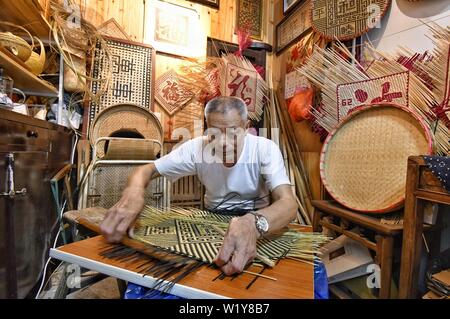 (190704) -- DEQING, 4 luglio 2019 (Xinhua) -- ma di Jilin, un ereditiere di Ma striscia di bambù maglia, lavora presso il suo negozio in Xinshi township di Deqing County, est della Cina di Provincia dello Zhejiang, 4 luglio 2019. Ma Jilin, 74 è un ereditiere di Ma striscia di bambù maglia che è stata indicata come una cultura immateriale patrimonio di Huzhou City nel 2019. Ma ha iniziato a imparare l'artigianato dopo che il suo padre quando era 10. Egli ha iniziato a fare una vita in tutta la Cina con il suo padre all'età di 15. Durante gli ultimi 60 anni, ma di Jilin è stata impegnata per ereditare e promozione ma la striscia di bambù maglia. Furt Foto Stock