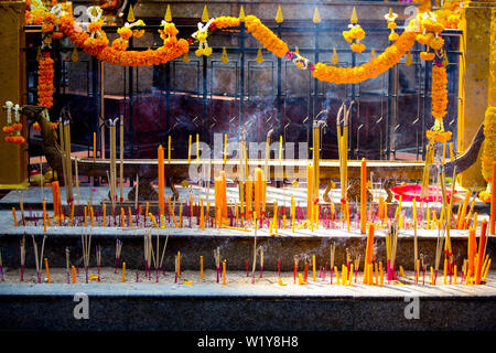 Brucia Incenso, candele giallo e calendula fiori sulla scalinata del Santuario di Erawan accanto al Grand Hyatt Erawan Hotel all'intersezione di ratto Foto Stock