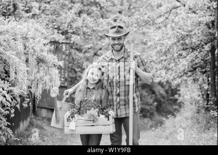 Padre e figlia sul ranch. azienda di famiglia. ecologia. Utensili da giardinaggio. bambina e uomo felice papà. La giornata della terra. molla village country. Facendo un bel mazzo di fiori. Foto Stock