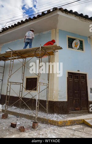 Chavín de Huantar, Ancash / Perù - 11. Giugno, 2016: stomemason e pittore di lavoratori su un ponteggio ristrutturare una casa in un remoto villaggio in Perù Foto Stock