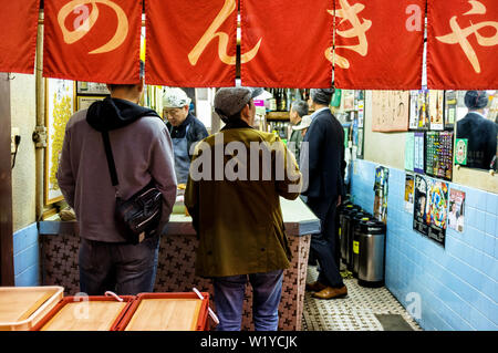 Aprile 18, 2019: uomini di mangiare in un piccolo bar di Osaka in Giappone Foto Stock