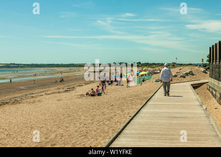 Claycastle, Youghal, Cork, Irlanda. 04 Luglio, 2019. Con temperature che raggiungono i 22 gradi, un uomo con la possibilità di passeggiare sul lungomare come lucertole da mare prendere alla spiaggia di Claycastle, Youghal, Co. Cork, Irlanda. Credito: David Creedon/Alamy Live News Foto Stock