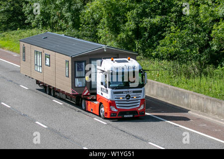 Merceders-Benz Hi-Line che trasporta roulotte statiche su rimorchi; veicoli commerciali HGV che viaggiano sulla M6 a Lancaster. REGNO UNITO Foto Stock