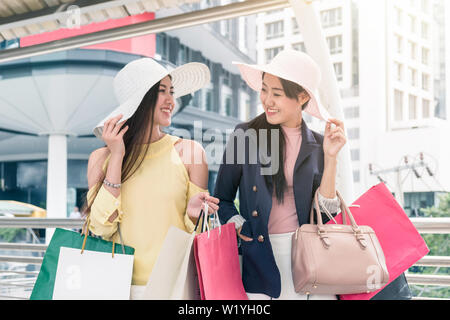 Due asian bellezza donna tenendo la carta colorata borsa con sorridente e felice dopo lo shopping Foto Stock