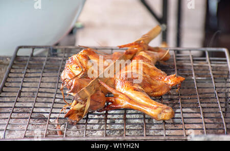 Pollo alla griglia in bambù sulla griglia della stufa. Foto Stock