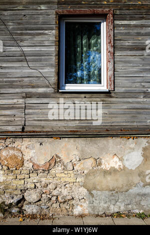 Vecchia finestra su un età compresa tra asse di legno parete. Dettagli architettonici. Fondo di architettura. Foto Stock