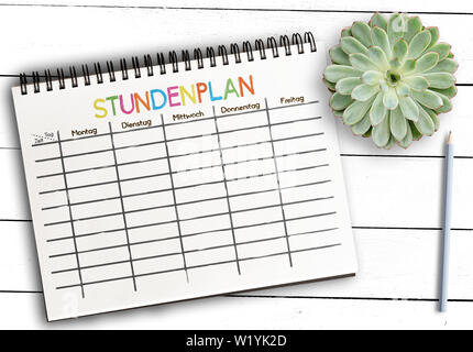 Vista superiore della classe pianificazione o modello di calendario con la parola tedesca STUNDENPLAN su notepad contro bianco rustico tavolo in legno Foto Stock