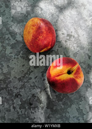 Fresche dolci gruppo di pesche su sfondo scuro in giardino. Foto Stock