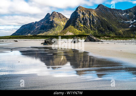 Esposizione lunga spiaggia di Flakstad,Isole Lofoten in Norvegia in una bella giornata di primavera con riflessioni sulla sabbia bagnata Foto Stock