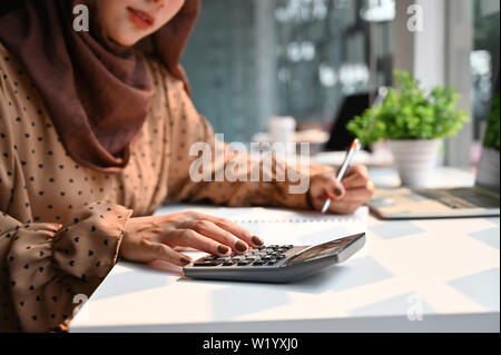 Islam donna lavora con finanze calcolare sulla calcolatrice. Foto Stock