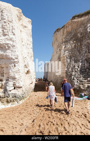 Un giovane a piedi attraverso il chalk pile a Botany Bay nel Kent, Inghilterra. Foto Stock