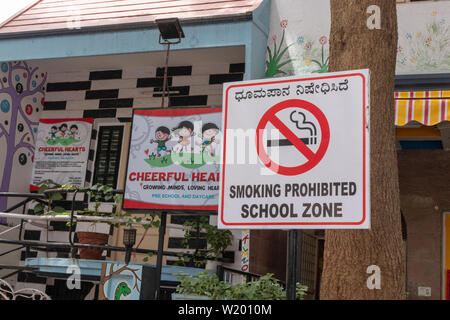 Bengaluru, India Giugno 27, 2019: Vietato fumare area scolastica bill board di fronte all'edificio scolastico Foto Stock