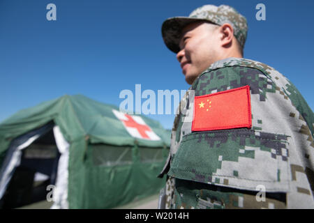 Feldkirchen, Germania. 04 Luglio, 2019. La bandiera della Repubblica popolare cinese è cucita sulla uniforme di un soldato del popolo cinese della Esercito di liberazione. Medical soldati del popolo cinese della Esercito di Liberazione hanno avviato un esercizio con la Bundeswehr in Baviera. Fino al 17 luglio, lo scenario di una comune missione ONU saranno addestrati a Feldkirchen nella Bassa Baviera. Credito: Armin Weigel/dpa/Alamy Live News Foto Stock